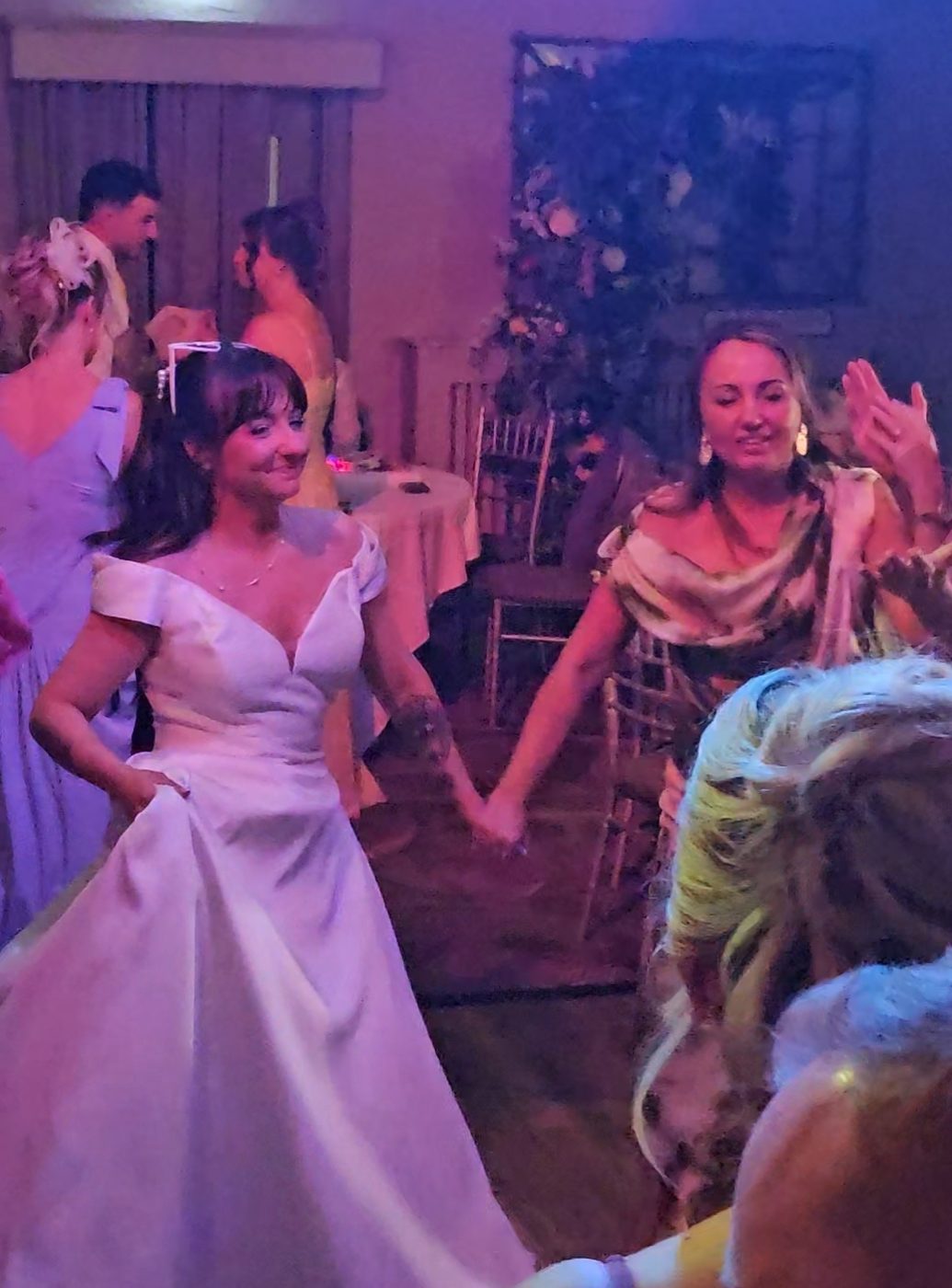 Bride dancing hand in hand with guests on the dancefloor at a Scottish wedding